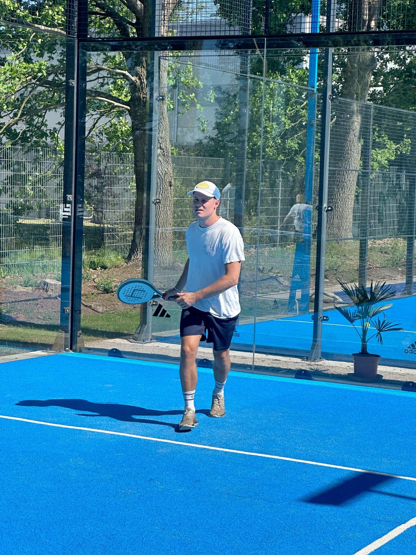 padel spieler mit heinsa schläger auf blauem outdoor court