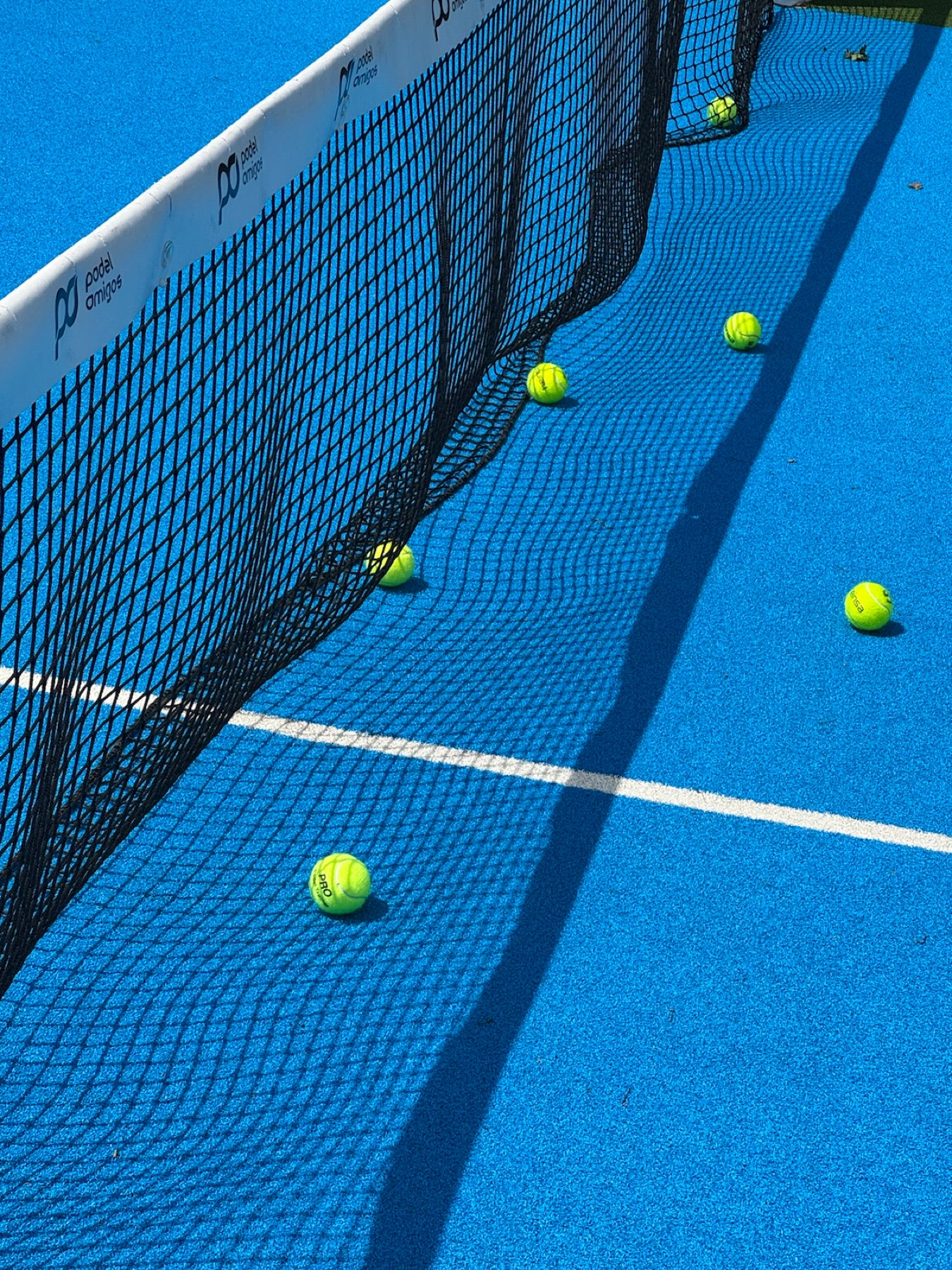 padelbälle am netz auf blauem court